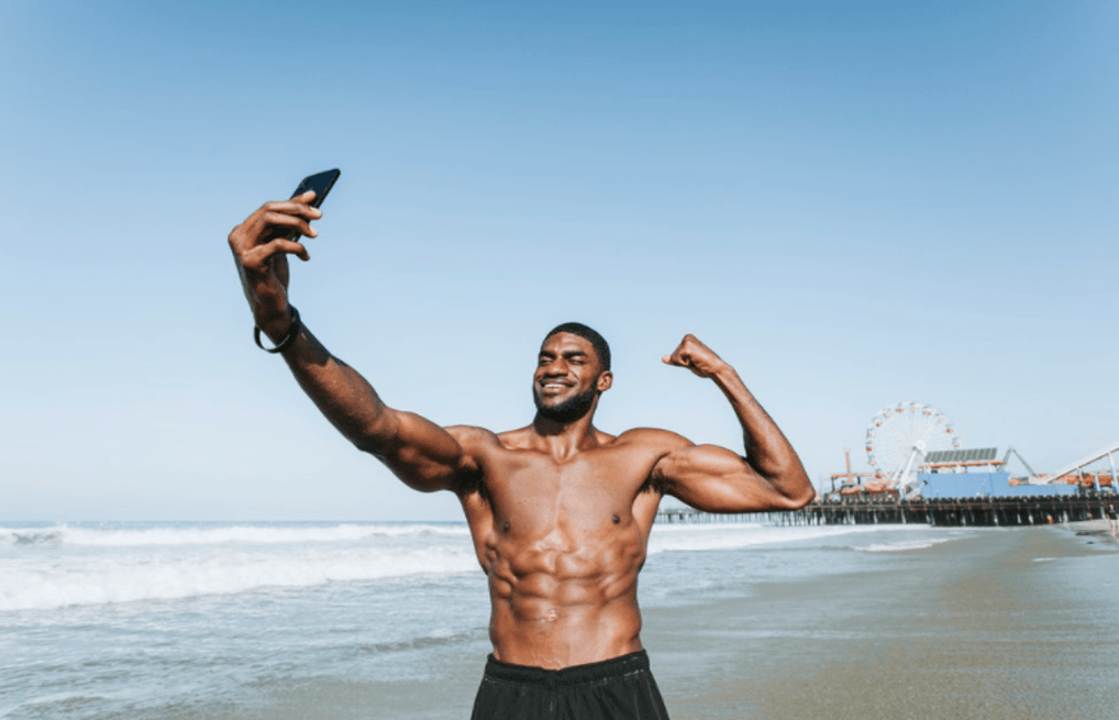 Man on the beach looking at phone