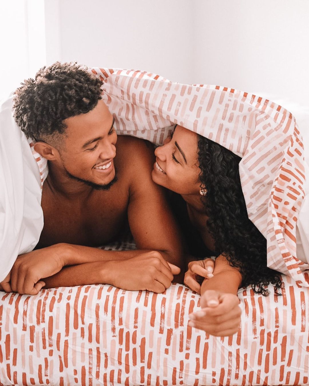 Couple under sheets (Courtesy of @tenesiaandterence)