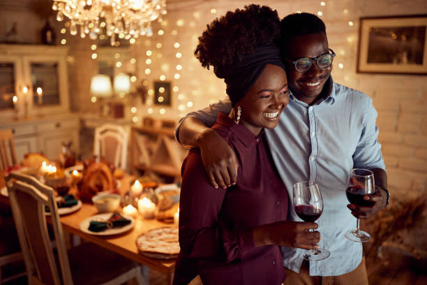Couple hugging and enjoying a glass of wine during the holidays