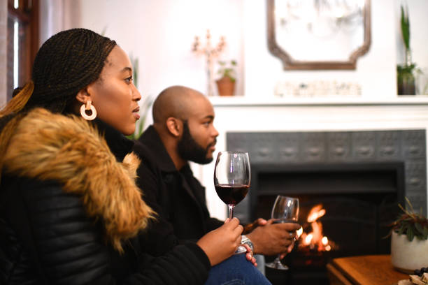 Couple listening to someone talk near a fireplace