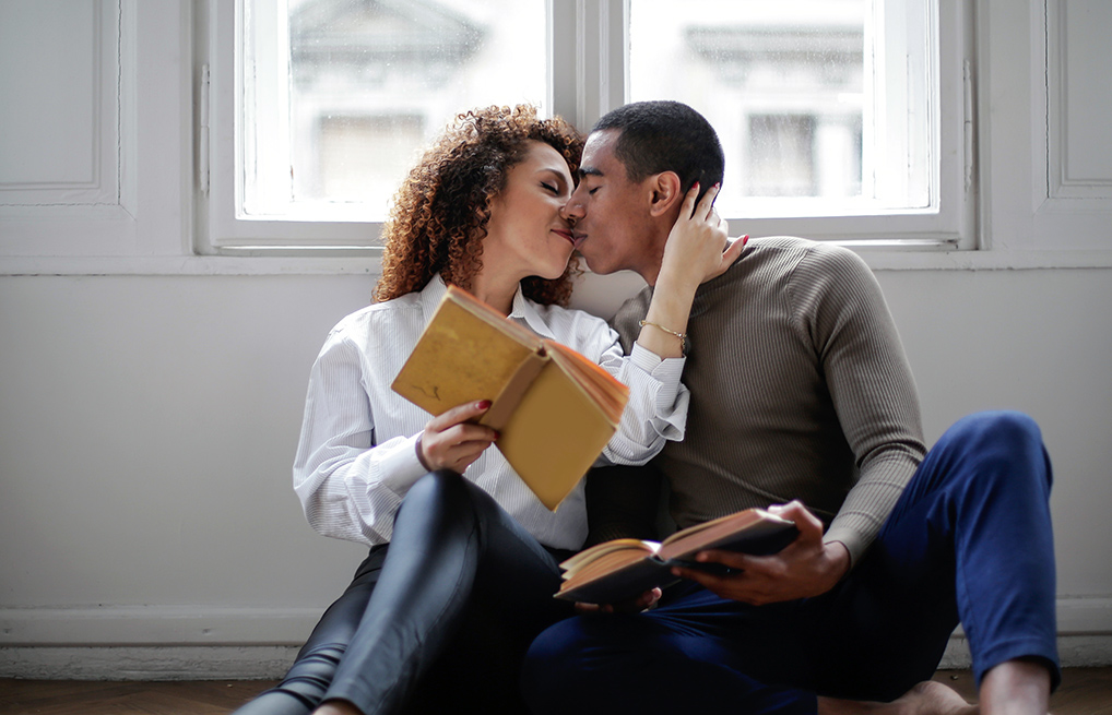 couple holding books and kissing