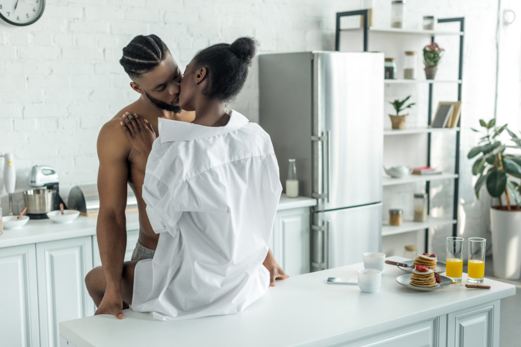 Couple Kissing On Kitchen Counter